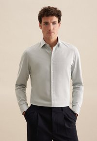 Lichtgroen overhem shirt met een klassieke kraag, lange mouwen en een gladde textuur, gecombineerd met donkere broeken.