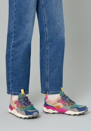 Multicolored sneakers feature blue, green, pink, and yellow accents; textured suede and mesh materials; chunky white sole with speckles.
