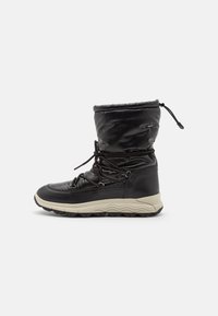 Bota de invierno negra aislante con cordones en el frente, parte superior acolchada, suela beige y cierre ajustable con cordón en la parte superior.