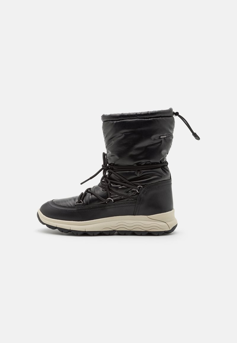 Bota de invierno negra aislante con cordones en el frente, parte superior acolchada, suela beige y cierre ajustable con cordón en la parte superior.