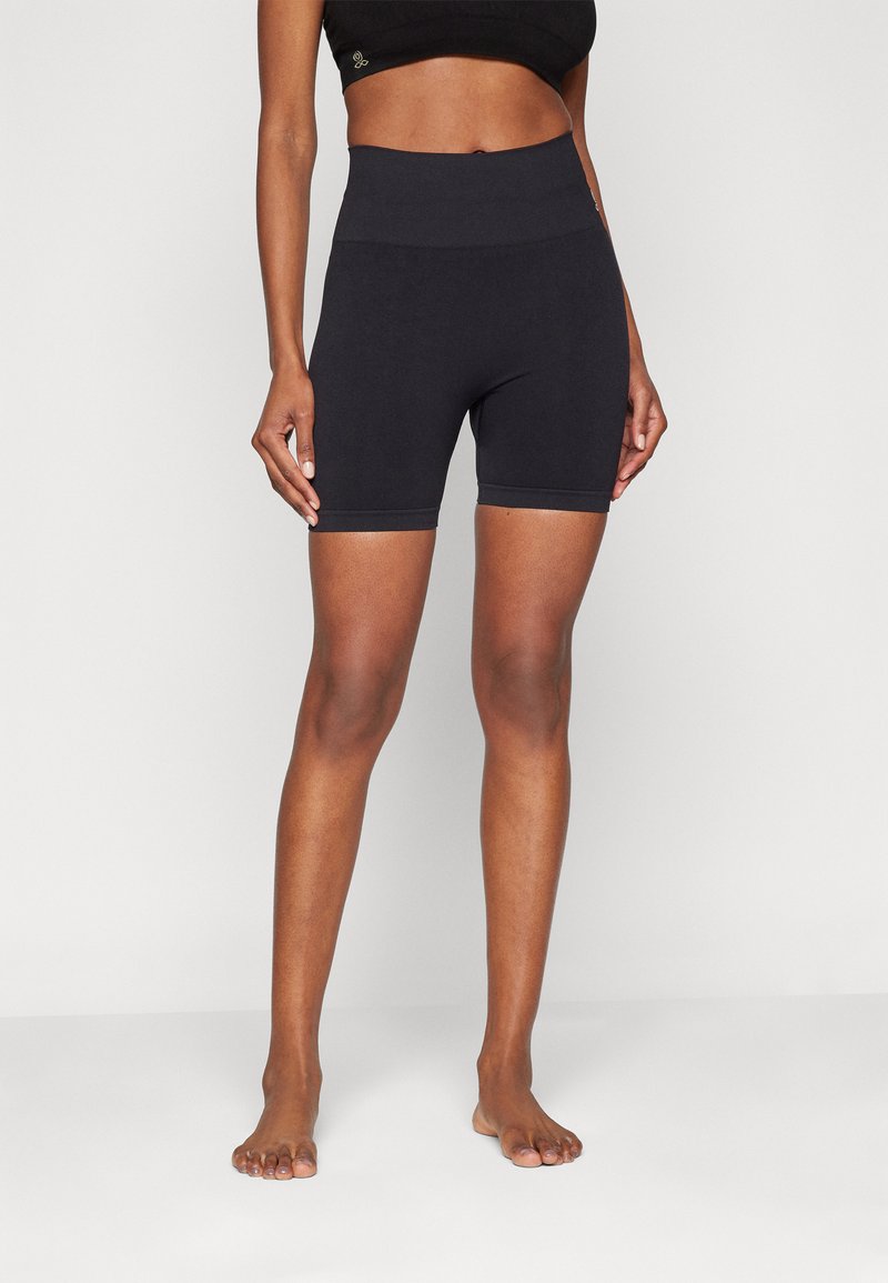 Pantaloni shorts neri a vita alta realizzati in tessuto elastico, design aderente, lunghezza fino a metà coscia, con una texture liscia e senza cuciture visibili.
