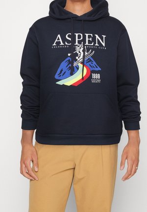 Marineblauwe capuchontrui met een grafisch ontwerp van bergen en een skiër, geaccentueerd met regenboogkleuren en een zak aan de voorkant.