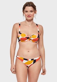 Conjunto de bikini con un patrón geométrico multicolor que presenta acentos en naranja, amarillo y negro; incluye un detalle anudado en la parte superior.