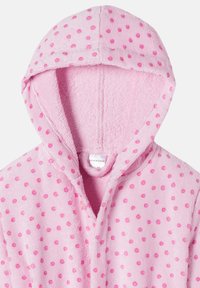 Rosa huva badrock i mjuk frotté, med prickigt mönster i mörkare rosa. Inkluderar frontöppning och handdukstextur.