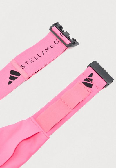Ροζ ελαστική αθλητική κορδέλα με μαύρα πλαστικά κλιπ, που φέρει τα λογότυπα Stella McCartney και Adidas σε ανοιχτό φόντο.