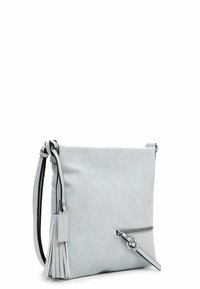 Lysegrå læder crossbody-taske med lynlås lomme foran og dekorativ kvast på justerbar rem mod hvid baggrund.