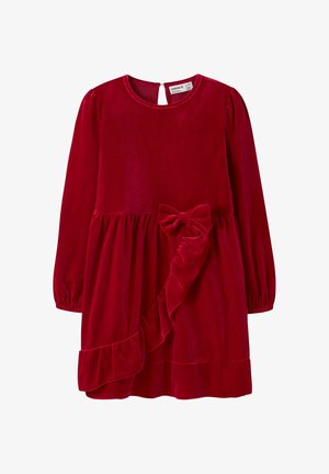 Robe en velours rouge à manches longues, décolleté rond et fermeture en forme de clé au dos. Elle présente un ourlet volanté et un accent en forme de nœud à la taille.