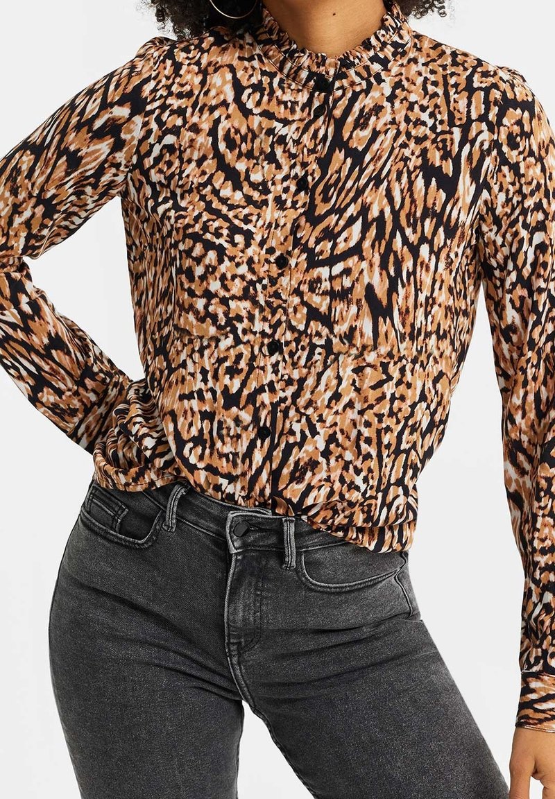 Topp med leopardtryck i nyanser av brunt, svart och kräm; har en krage, knappstängning fram och långa ärmar; strukturerat tyg.