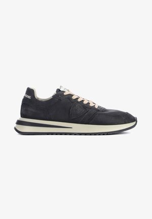 Sneaker in suede nero con lacci beige, suola spessa beige e logo in rilievo sul lato, mostrato dal lato destro.