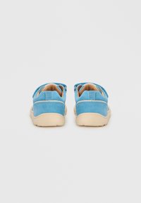 Παιδικά παπούτσια από μπλε σουέντ με μπεζ ελαστική σόλα, διαθέτουν ευέλικτο σχεδιασμό και χαμηλή γραμμή για εύκολη φορεσιά.