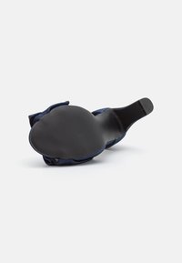 Navy blue shoe with a soft fabric upper, featuring a rounded toe and flat black rubber sole with textured detailing. Seamless design.