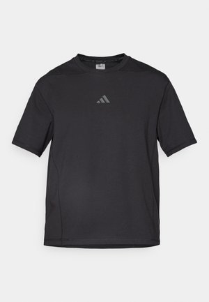 Svart atletisk t-shirt tillverkad av ett ventilerande material, med korta ärmar, rund hals och en reflexlogotyp på bröstet.