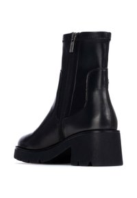 Stivale alla caviglia in pelle nera con tacco spesso nero, con zip laterali e texture liscia. Il design include una punta arrotondata e accentuazioni minime.