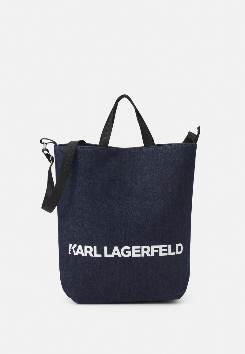 Sac cabas en tissu bleu foncé avec poignées noires et bandoulière, avec texte blanc "KARL LAGERFELD" au recto.