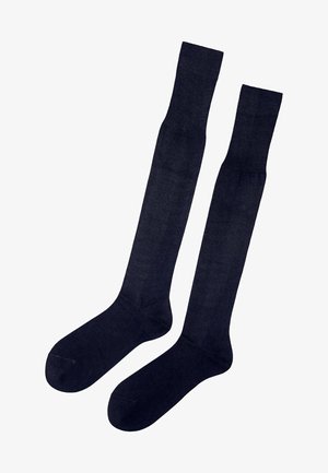 Ciemnoniebieskie skarpetki do kolan wykonane z miękkiego, lekkiego materiału. Posiadają gładką teksturę, wzmocniony czubek oraz wykończone krawędzie.