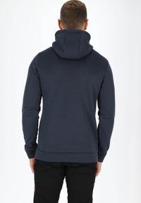 Felpa blu navy con collo alto, realizzata in tessuto morbido. Presenta maniche lunghe e orlo a coste, mostrando un design pulito e semplice.