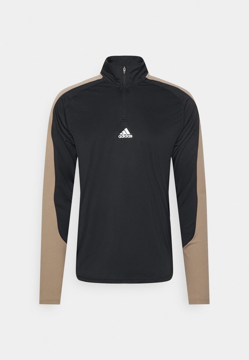Zwarte sportieve pullover met lange mouwen, ritskraag en beige accenten op de schouders. Heeft een wit Adidas-logo op de borst.