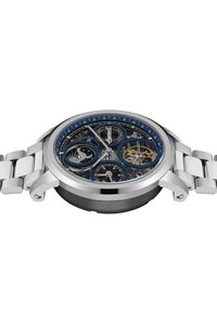 Zilveren roestvrijstalen horloge met een blauwe wijzerplaat, skeletontwerp, drie sub-dials en een verbonden metalen band. Opmerkelijke details omvatten tandwielaccenten.