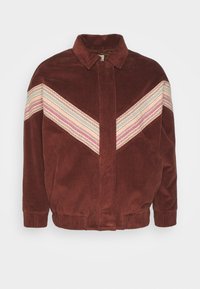 Veste en velours côtelé marron avec des rayures chevrons zigzag crème, rose et vert clair sur la poitrine et les manches, fermeture éclair devant, poignets et ourlet élastiques.