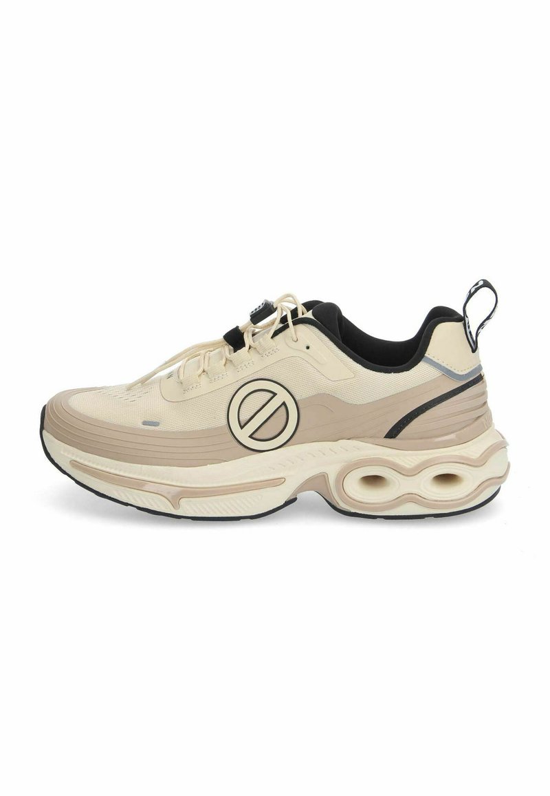 Beige sportieve schoen met een gestructureerde bovenkant, zwarte accenten, een opvallend cirkelvormig logo en een dikke, gewatteerde zool met holle secties.