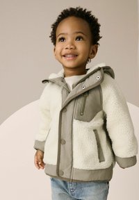 Kinderjacke mit einem weichen, weißen Schafslederkörper und einer hellgrauen Nylonkapuze sowie -ärmel. Sie verfügt über Druckknöpfe und eine Reißverschlusstasche.
