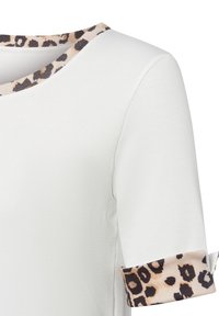 Weißes, geripptes T-Shirt mit einem Leopardenmuster um den runden Ausschnitt und die Ärmelbündchen; kurze Ärmel mit aufgerolltem Design.