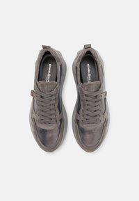 Zapatillas de deporte gris oscuro con una mezcla de materiales lisos y texturizados. Punta redonda, diseño con cordones y suela acolchada. Marca sutilmente visible.