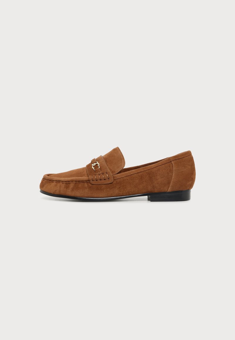 Mocassin en daim marron avec un petit détail mors doré, talon bas noir et coutures style mocassin sur fond blanc.