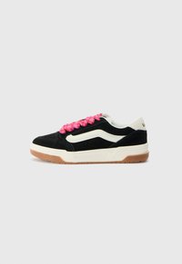 Black suede sneakers with cream accents and a rubber gum sole. Features thick pink laces and a low-top design. Ventilation holes on the sides.