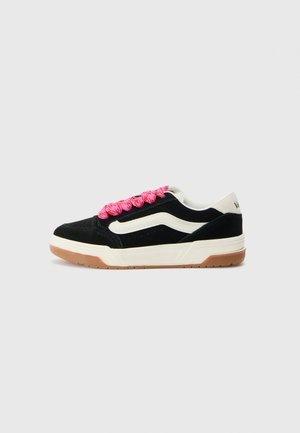 Black suede sneakers with cream accents and a rubber gum sole. Features thick pink laces and a low-top design. Ventilation holes on the sides.