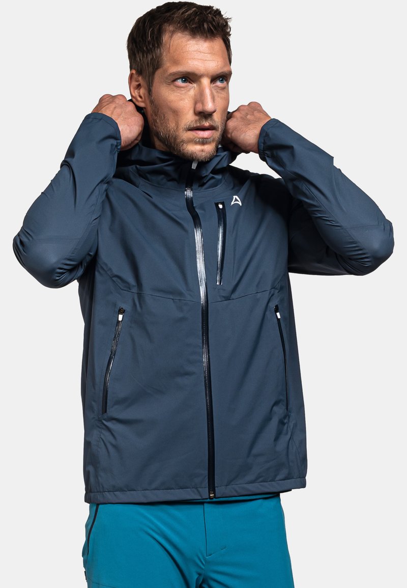 Marineblaue, wasserdichte Jacke mit Kapuze, ausgestattet mit Reißverschluss-Taschen vorne und einem Reißverschluss-Verschluss. Glattes Material mit einem athletischen Schnitt.