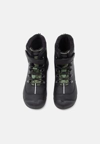 Crne i zelene vodootporne čizme s teksturiranom završnom obradom, podstavljenim ovratnikom, prilagodljivim remenom i reflektirajućom prugom na prednjem dijelu.