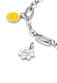 Braccialetto in argento con un ciondolo a forma di faccina sorridente gialla e un pendente a forma di fiore, entrambi con superfici lisce e colori vivaci.