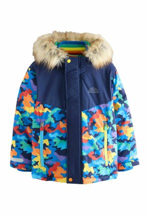 Giacca invernale colorata con parte superiore blu navy, cappuccio in pelliccia sintetica e vivaci motivi camouflage in arancione, verde, blu e giallo.