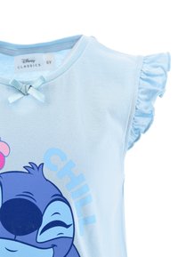 Jasnoniebieska bawełniana koszulka z falbaniastymi rękawami i kokardką przy dekolcie. Zawiera grafikę postaci z napisem "CHILL".