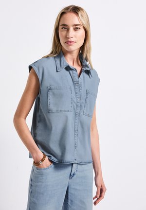 Camicia in denim senza maniche di colore blu chiaro con colletto, chiusura frontale con bottoni e due tasche sul petto; texture liscia e design casual.