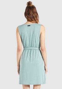 Une robe sans manches, de couleur bleu canard, fabriquée en tissu doux, avec une taille élastique, un col rond et une jupe de longueur mi-cuisse.