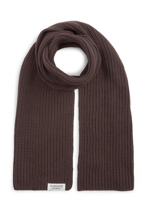 Brun strikket halstørklæde foldet i en løkke med en hvid "Tommy Jeans" etiket syet nær den ene ende på en hvid baggrund.