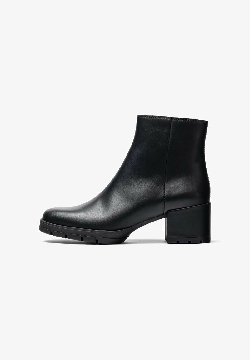 Bottine noire en cuir avec une finition lisse, bout rond et un gros talon bloc. Présente un design minimaliste et une semelle en caoutchouc plate.