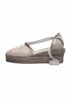 Zapato espadrille de cuña con empeine de cuero beige, suela plataforma de yute trenzado y cierre con lazo en el tobillo.