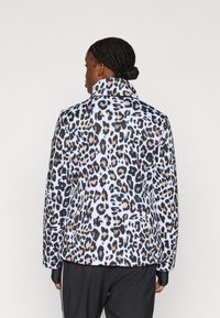 Giacca con stampa animalier a macchie color nero, beige e azzurro, con collo a risvolto, realizzata in tessuto liscio.