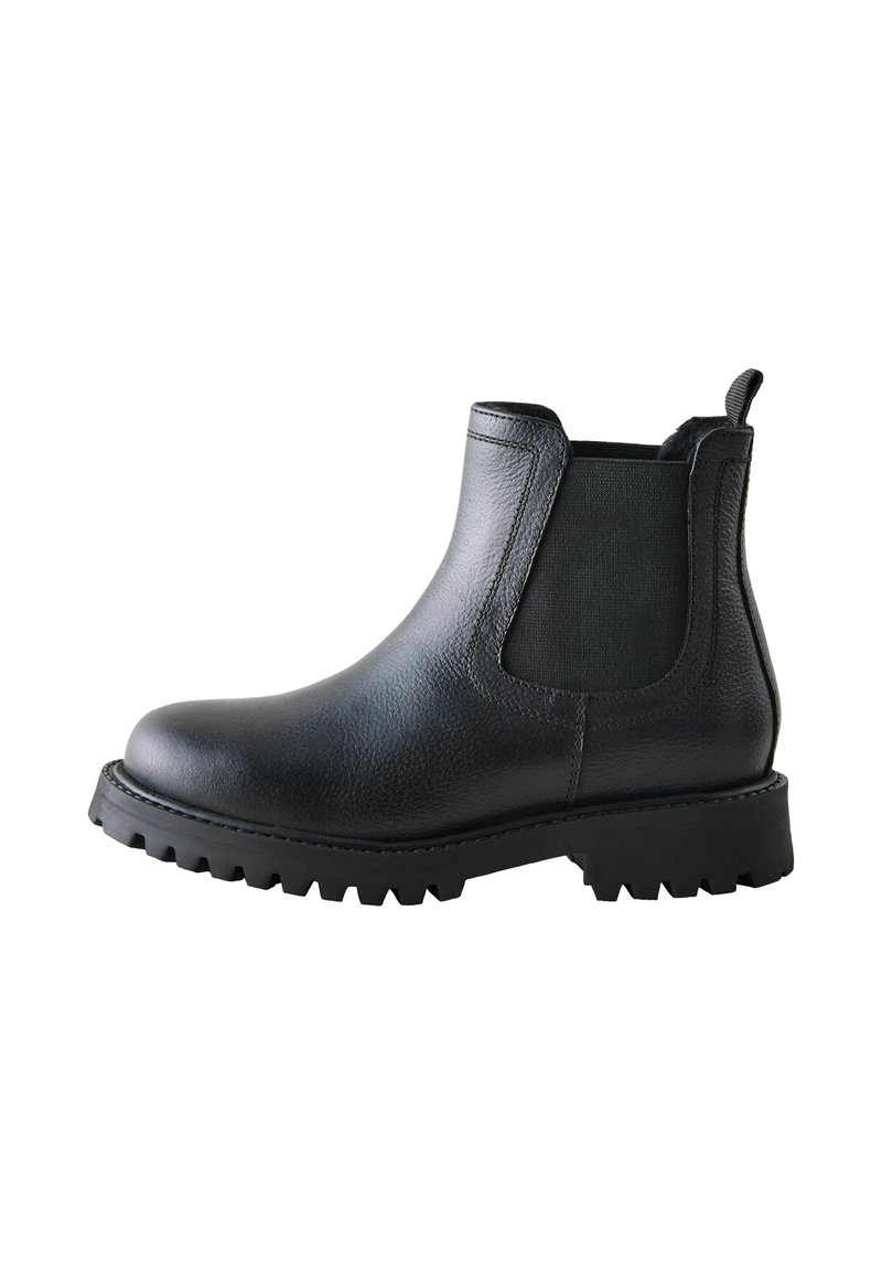 Bota Chelsea de cuero negra con paneles laterales elásticos y suela resistente, vista desde un lado. Cuenta con una lengüeta para facilitar su puesta.