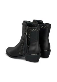 Botines de cuero negro con detalles de remaches, tirador de cremallera con borlas y un tacón bajo. Textura suave y forma estructurada.