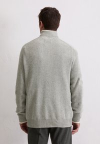 Hellegrauer, gerippter Pullover mit einem hohen Kragen und langen Ärmeln. Besitzt ein strukturiertes Strickmuster und ein einfarbiges Design.