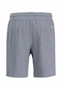 Shorts en tissu gris clair texturé avec une ceinture élastique et une poche arrière sur le côté droit, conçus pour un usage décontracté.
