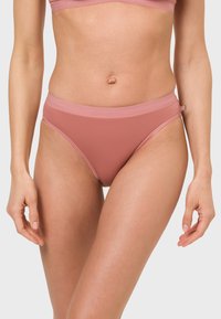 Helle rosafarbene nahtlose Bikiniunterwäsche mit einem weichen elastischen Bund, der ein minimalistisches Design und eine glatte Textur aufweist.