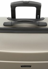 Maleta rígida Witthcen, plateada con acabado texturizado, presenta un mango telescópico negro y cierre de cremallera, etiquetada con el logo de la marca.