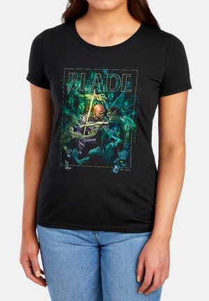 Woman wearing black t-shirt with colorful graphic of a soldier fighting green monsters and the word "BLADE" above them.