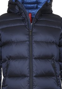 Giacca puffer blu navy con zip frontale, fodera interna blu, design a righe orizzontali e due tasche laterali con zip.