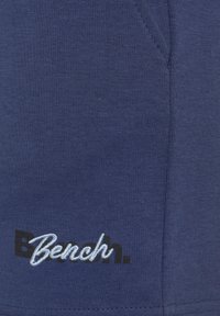 Navyfarbener Sweatshirtstoff mit strukturiertem Finish, ausgestattet mit einem auffälligen bestickten "Bench."-Logo in Schwarz und Hellblau.